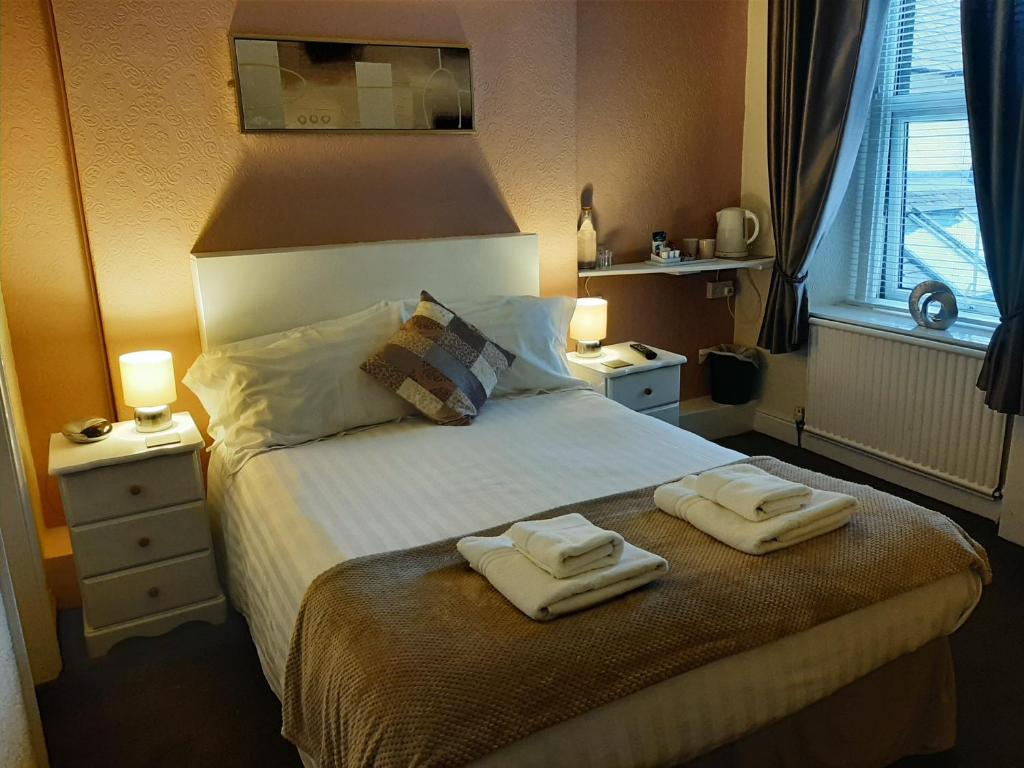 1 dormitorio con 1 cama con 2 toallas en Lyndhurst, en Keswick