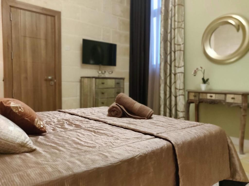 a bedroom with a bed with a mirror and a television at Charming Town House Suite - Close to Airport in Paola