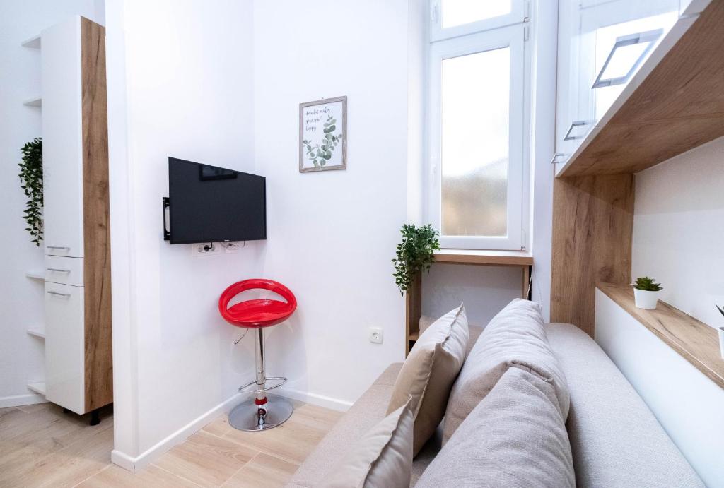 a living room with a couch and a red stool at Apartments Fiorello in Rijeka