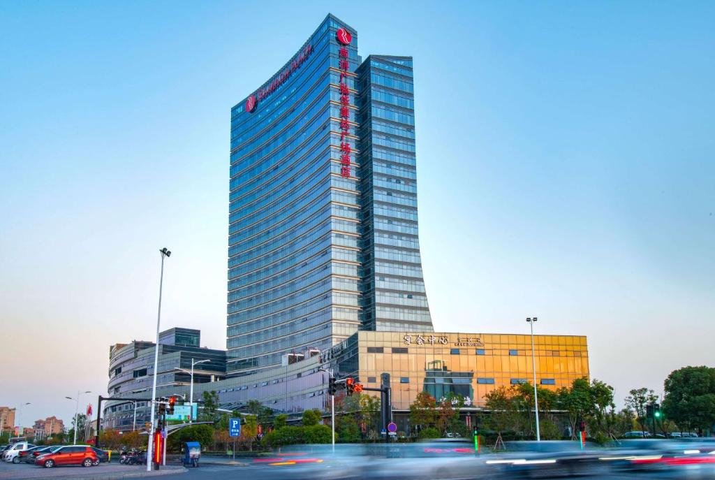 a tall building with cars in front of it at Ramada Plaza by Wyndham Nanxun in Huzhou