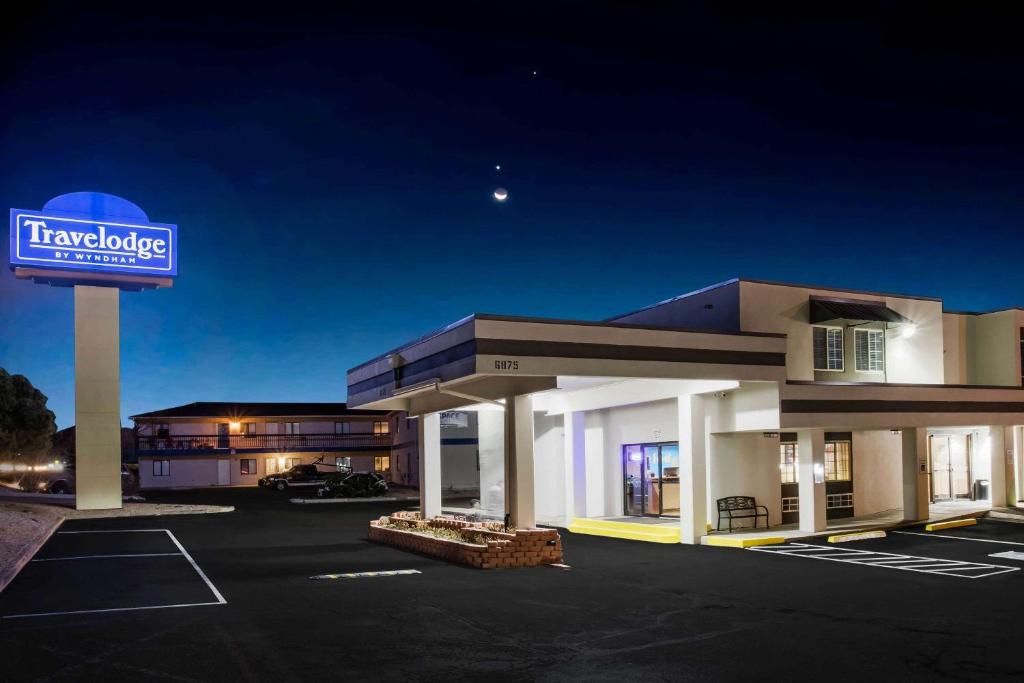 un hotel con un cartel en un estacionamiento en Travelodge by Wyndham Colorado Springs Airport/Peterson AFB en Colorado Springs