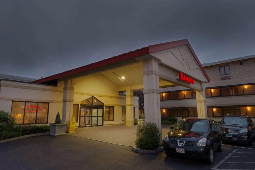 a hotel with a car parked in a parking lot at Ramada by Wyndham Boston in Boston