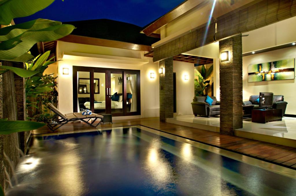 ein Haus mit einem Pool vor einem Haus in der Unterkunft My Villas In Bali in Seminyak