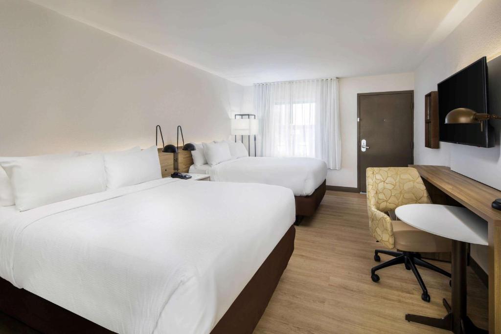 a hotel room with two beds and a desk at Wyndham Garden Marietta Atlanta North in Marietta