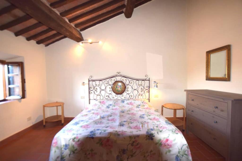a bedroom with a large bed and a dresser at LA LOGGETTA in Campiglia Marittima
