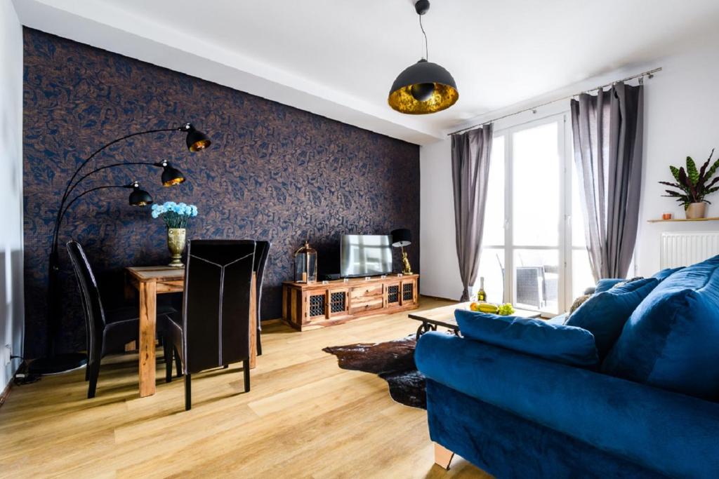 ein Wohnzimmer mit einem blauen Sofa und einem Tisch in der Unterkunft Blue House Warsaw Center in Warschau