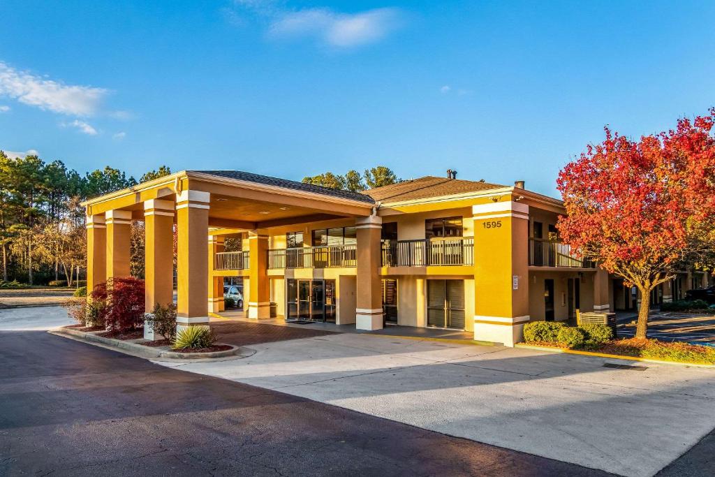 a large yellow building with a parking lot at Quality Inn Stone Mountain Atlanta in Stone Mountain
