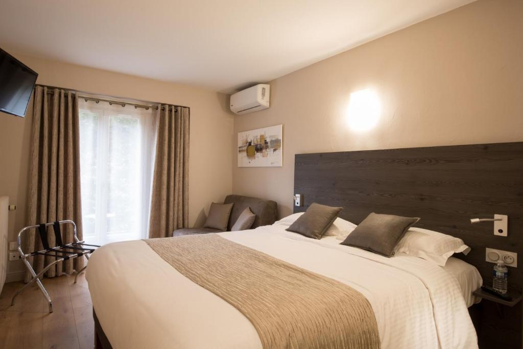 Postel nebo postele na pokoji v ubytování Logis Hotel Le Petit Casset