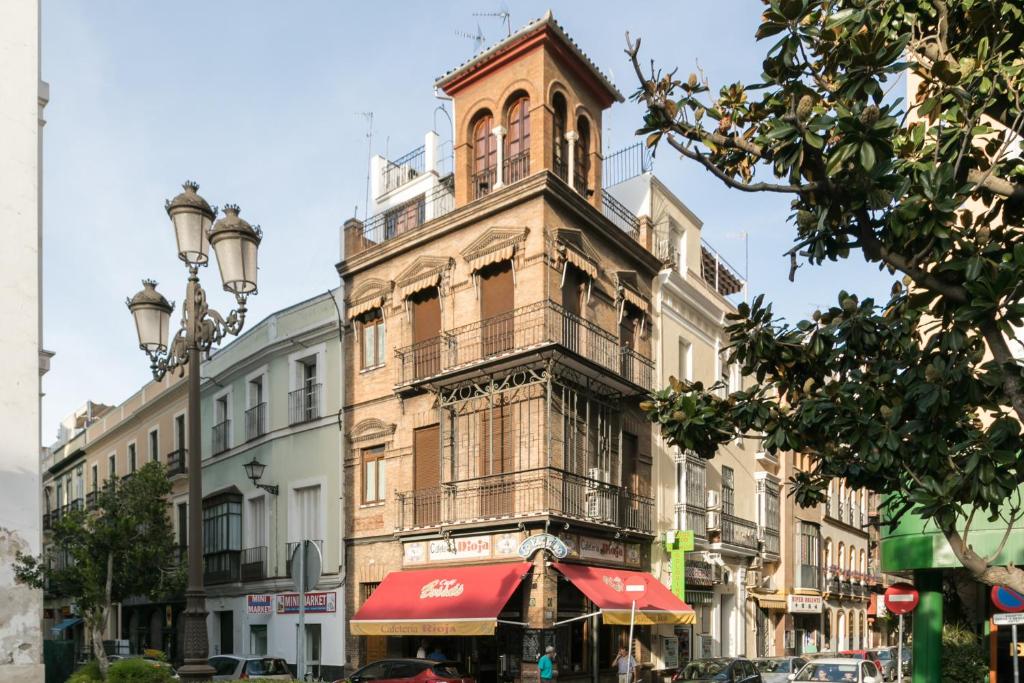 un edificio alto con una torre de reloj en una calle en Duplex Jesús Gran Poder 4. Plaza de la Gavidia en Sevilla