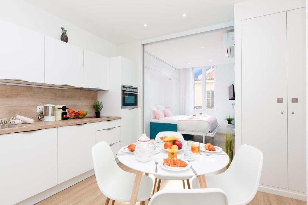 - une cuisine blanche avec une table et des fruits dans l'établissement L'Albion YourHostHelper, à Cannes