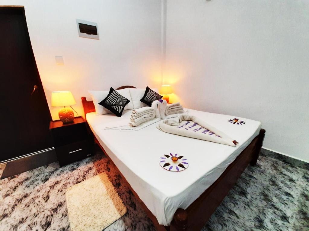 - une chambre avec 2 lits dotés de draps et d'oreillers blancs dans l'établissement Dream Villa Sigiriya, à Sigirîya