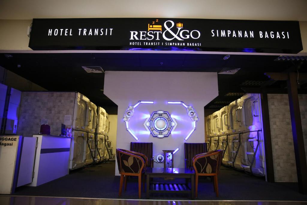 a stage with two chairs and a table and a sign at TBS Rest & Go Transit Motel in Kuala Lumpur