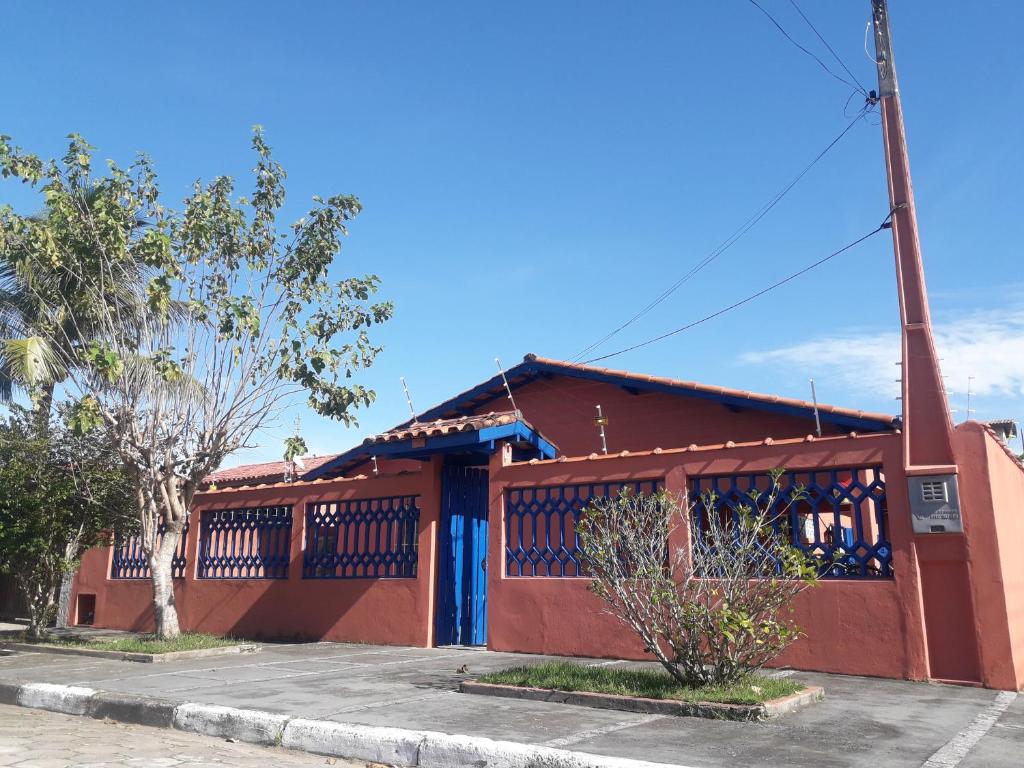 a red building with a blue door and a pole at Casa Indaiá BnB in Caraguatatuba