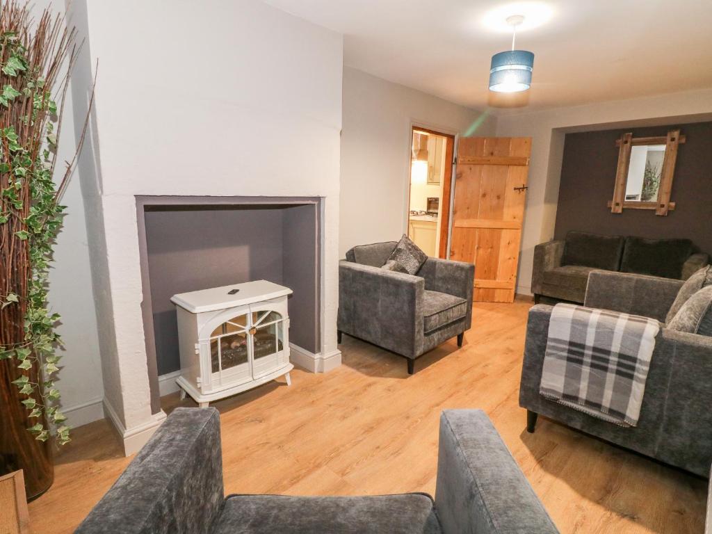 a living room with couches and a fire place at Milford Cottage in Belper