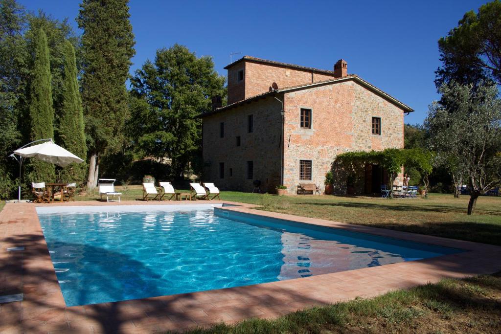 a large swimming pool in front of a building at Salceta, a Tuscany Country House in Campogialli