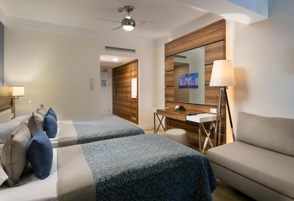 a hotel room with two beds and a couch at Limak Atlantis Deluxe Hotel Belek in Belek