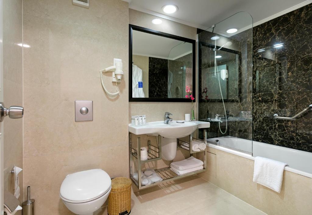 a bathroom with a sink and a toilet and a shower at Limak Atlantis Deluxe Hotel Belek in Belek