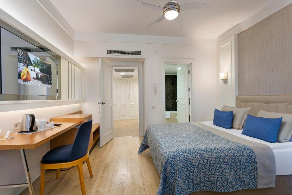 a hotel room with a bed and a desk at Limak Atlantis Deluxe Hotel Belek in Belek