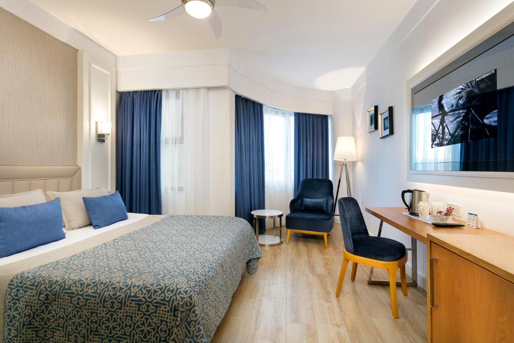 a hotel room with a bed and a desk at Limak Atlantis Deluxe Hotel Belek in Belek