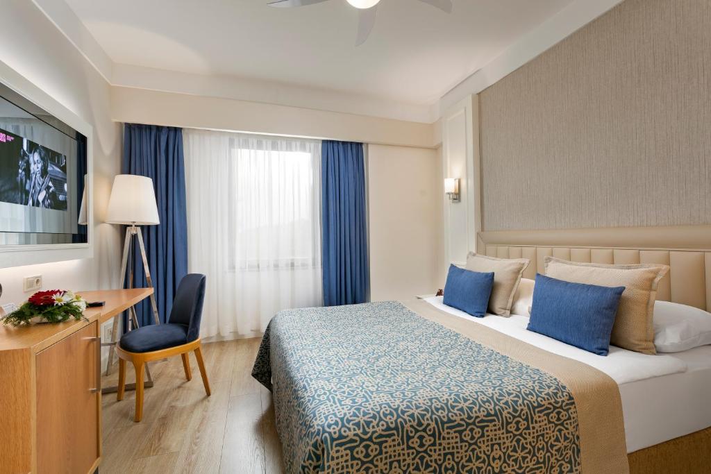 a hotel room with a bed and a desk and a television at Limak Atlantis Deluxe Hotel Belek in Belek