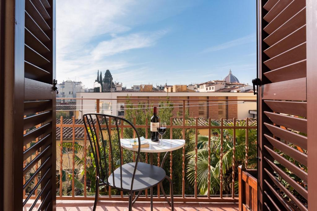 balcone con tavolo e bicchiere di vino di Lovely apartment with balcony a Firenze