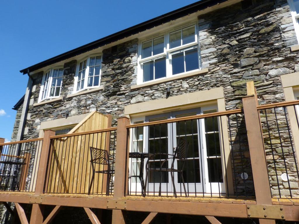 a home with a deck and a stone building at Pearsall in Ambleside