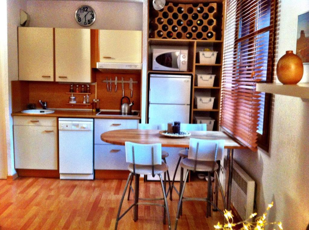 uma cozinha com electrodomésticos brancos e uma mesa e cadeiras em Estudio con piscina en Enveitg em Enveitg
