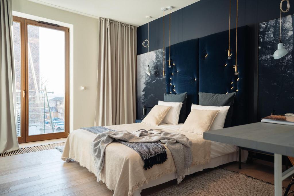 1 dormitorio con cama y pared azul en Wawel Apartments by LoftAffair, en Cracovia