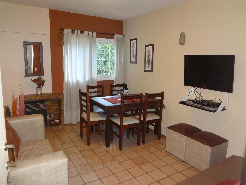 a dining room with a table and chairs and a television at Depto en Parque Central in Mendoza