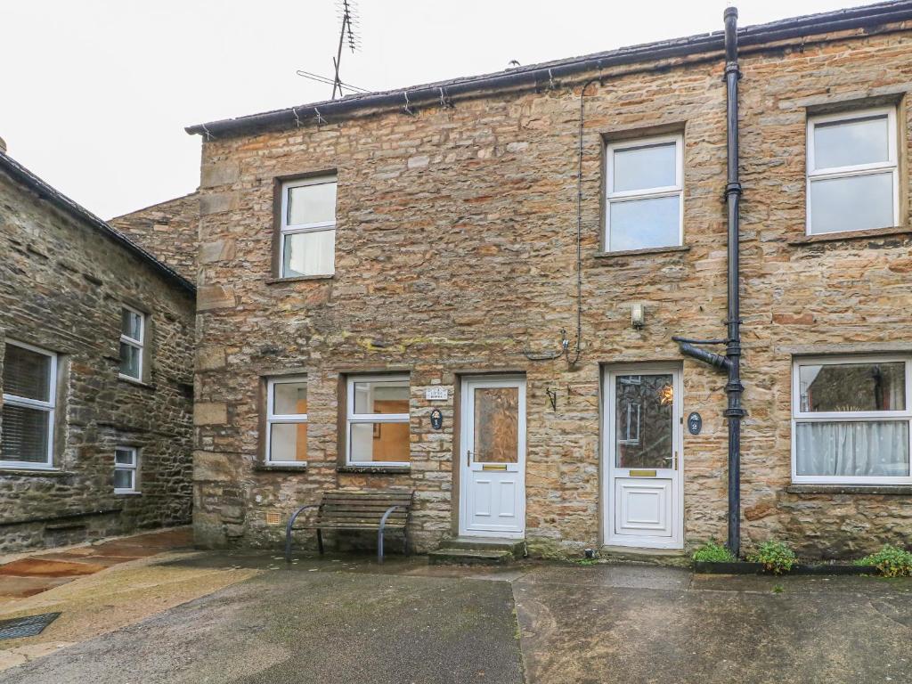 a brick building with a bench in front of it at The Little Bower in Hawes