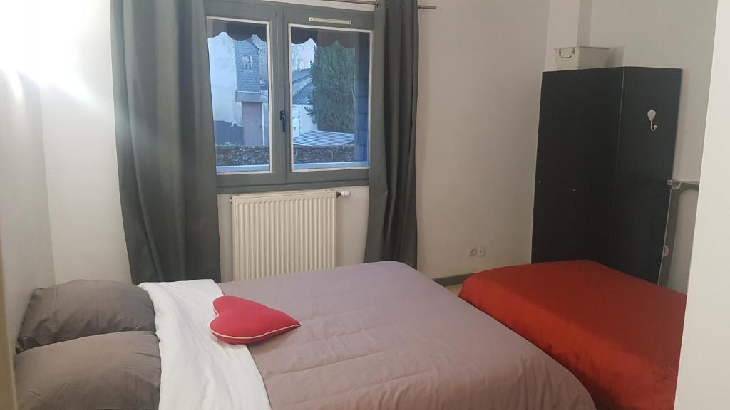 een slaapkamer met een bed met een rood kussen erop bij Appart entier 1 ch à ch-gontier 1er ou 2eme étage in Château-Gontier