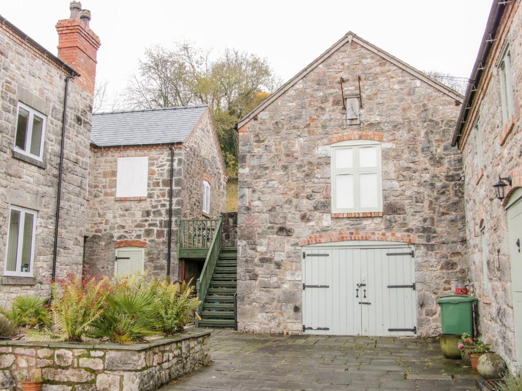 une ancienne maison en briques avec un garage blanc dans l'établissement The Hayloft, à Oswestry