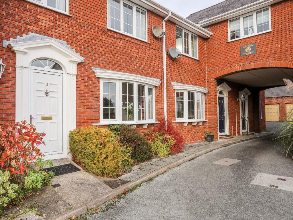 a red brick house with a white door at Sea View Cottage in Menai Bridge