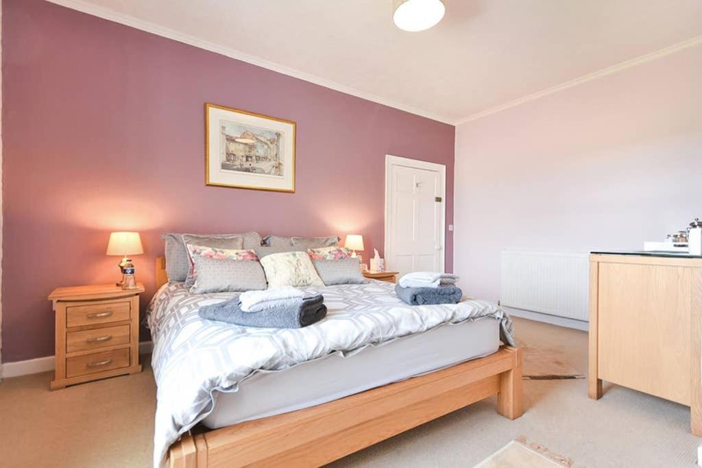 1 dormitorio con 1 cama grande y paredes moradas en Rocking Chair Farmhouse, en Alnwick