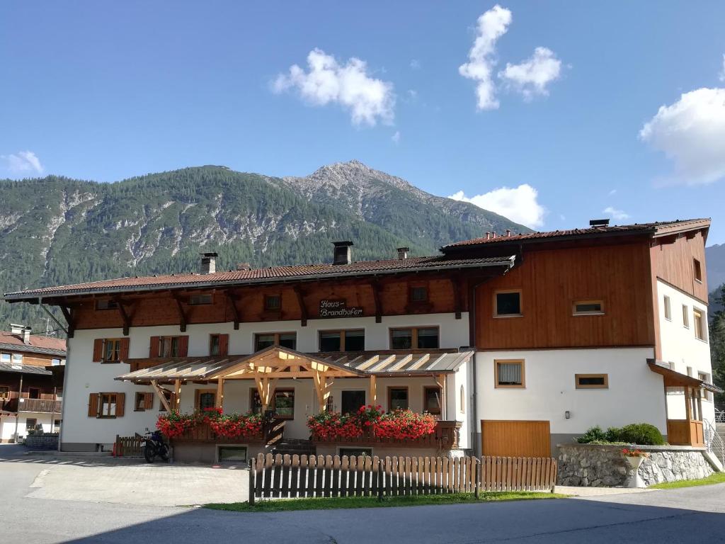 a large building with a mountain in the background at Haus Brandhofer in Häselgehr