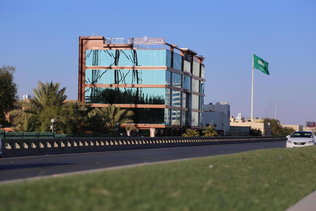 un gran edificio de cristal al lado de una carretera en Brand Al Qassim Hotel en Buraidah