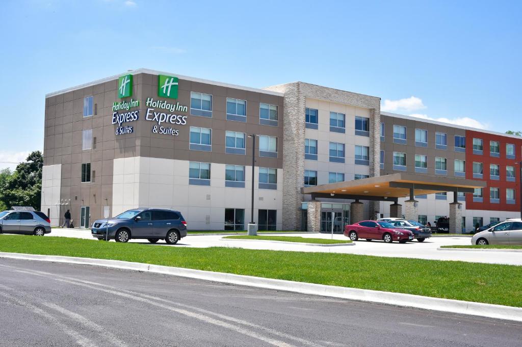 un gran edificio con coches estacionados en un estacionamiento en Holiday Inn Express & Suites - Bensenville - O'Hare, an IHG Hotel en Bensenville