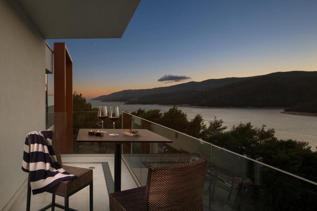 balcón con mesa, sillas y vistas al agua en Luxury Apartment Istra Rabac - Penthouse RAB, en Rabac