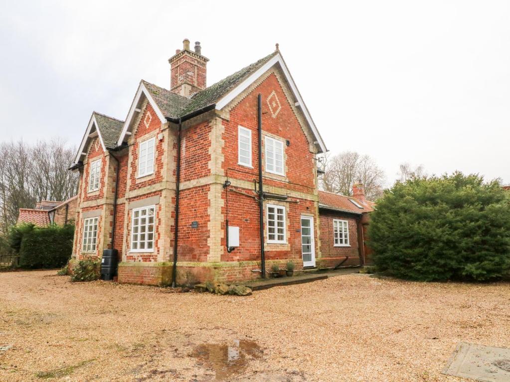 an old red brick house with a large yard at Pool Cottage in Lincoln