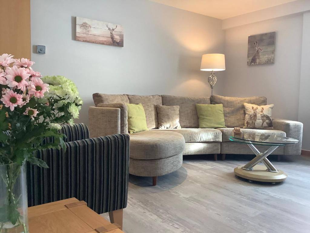 uma sala de estar com um sofá e uma mesa em 37 Farraline Court, City Centre apartment em Inverness