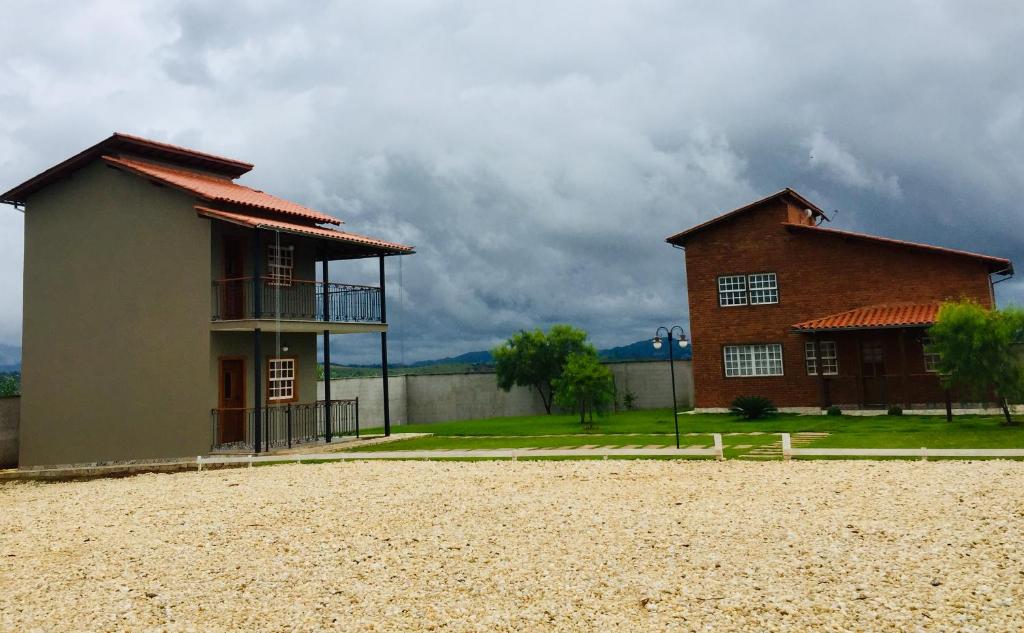 ein Gebäude auf einem Feld neben einem Haus in der Unterkunft Vilarejo São José in Tiradentes