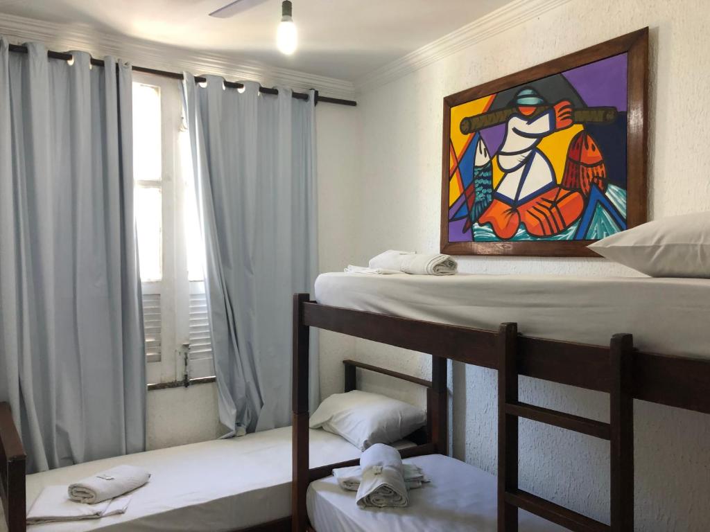 Pousada Suítes Do Pelô في سلفادور: غرفة بسريرين بطابقين ولوحة على الحائط