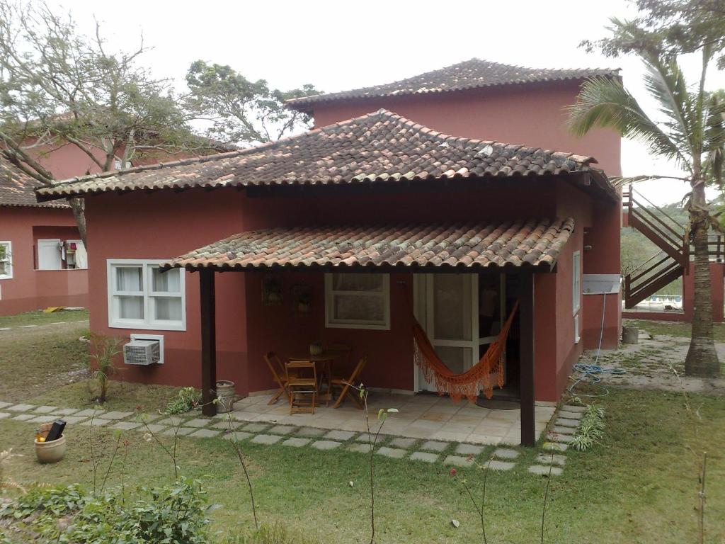 una casa roja con un patio frente a ella en Linda casa na Praia em Caravelas - Paraíso de Búzios, en Búzios