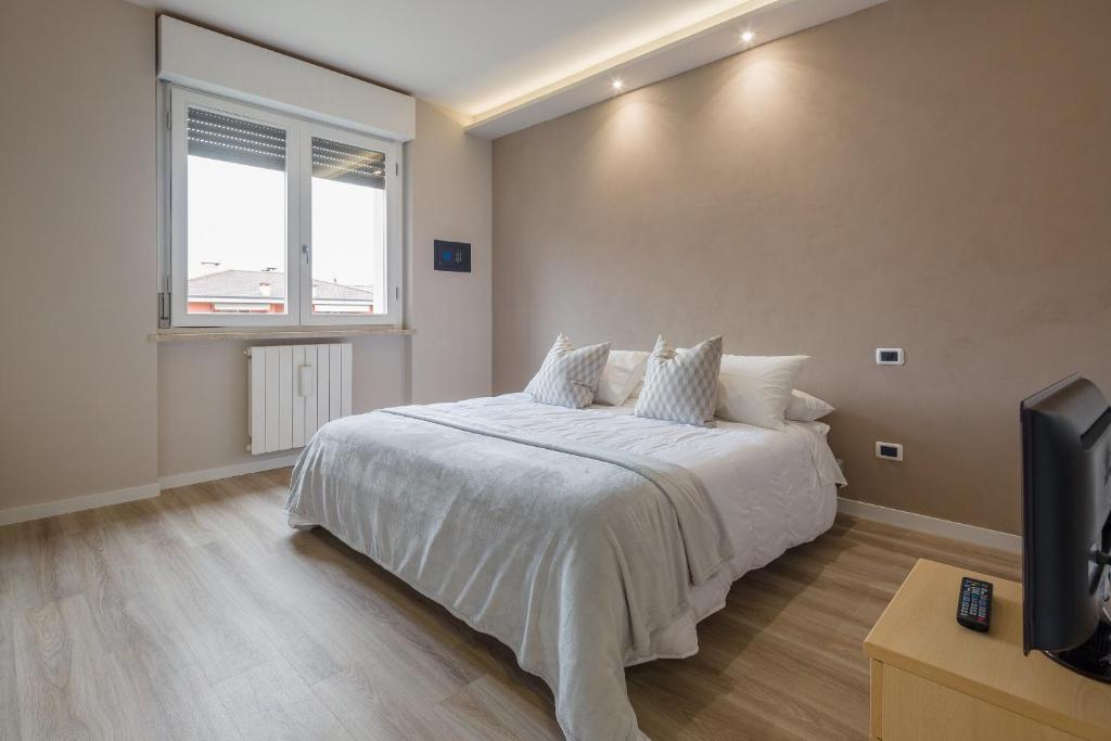 1 dormitorio con 1 cama blanca, ventana y TV en Canna da zucchero en Verona