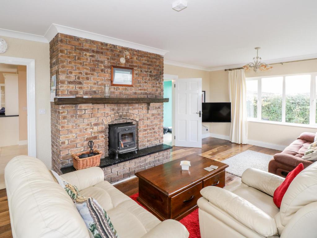 a living room with a brick fireplace at Clifftop Haven in Renvyle