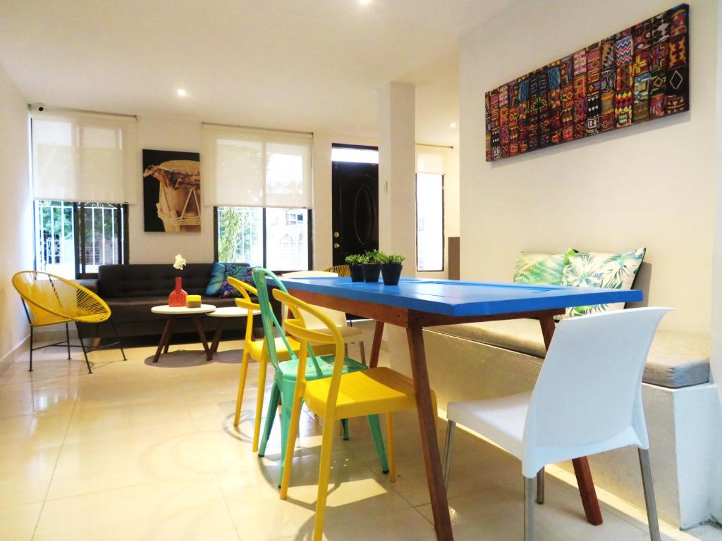 uma sala de jantar com uma mesa azul e cadeiras amarelas em SAN JACINTO HOSTEL em Cartagena de Indias