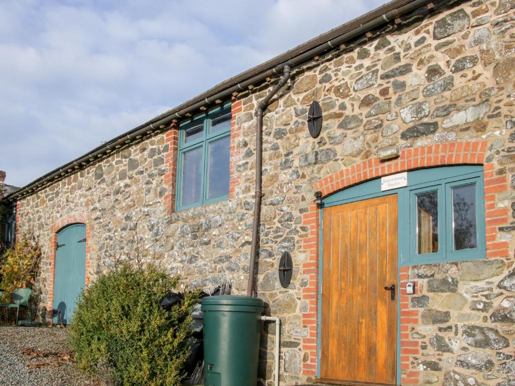 a stone house with a wooden door and windows at Stiperstones View in Shrewsbury