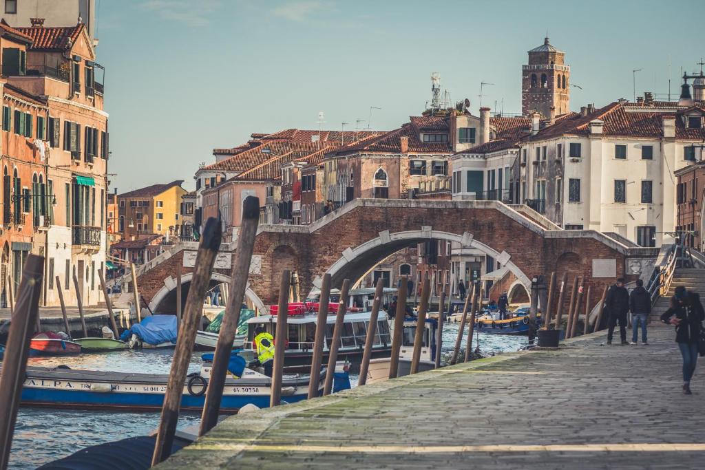 eine Brücke über einen Kanal mit Booten und Gebäuden in der Unterkunft Ai tre Archi apartment in Venedig
