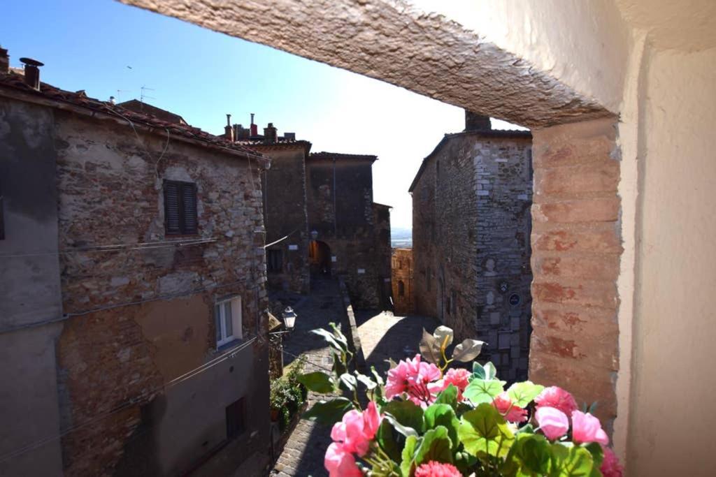 a view of an alley with pink flowers on a building at LA TORRETTA in Campiglia Marittima