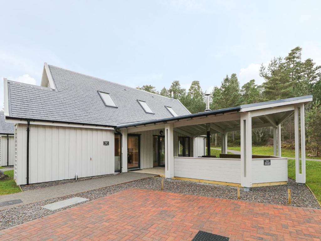 a house with a garage and a roof at Mountain Hare Apartment in Kingussie